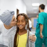 Sick woman with cancer hugging her young grandchild in hospital. Family support concept